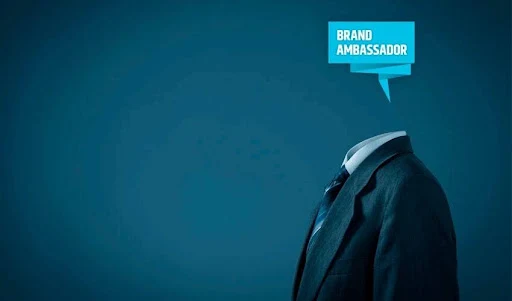 Conceptual image of a suit with a speech bubble reading brand ambassador against a blue background.
